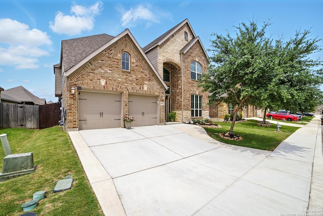 traditional-style house with fence, driveway, a front lawn, and brick siding