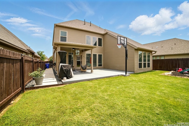 rear view of house featuring a lawn, a fenced backyard, and a patio