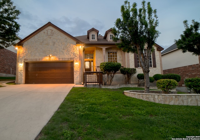 view of front facade featuring a garage, a front yard, stone siding, concrete driveway, and a porch