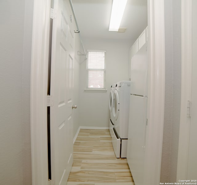 washroom with separate washer and dryer, laundry area, baseboards, and light wood-type flooring