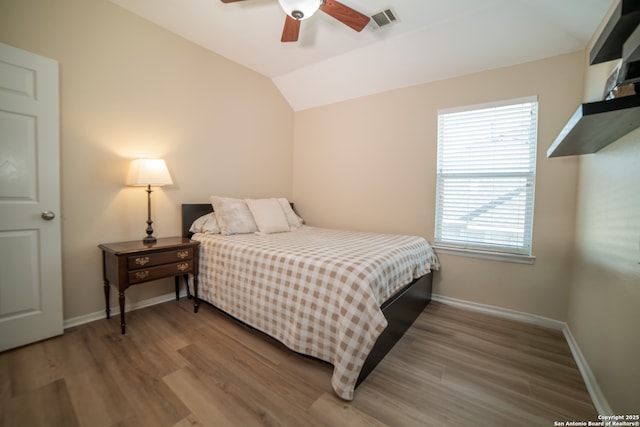 bedroom featuring ceiling fan, baseboards, wood finished floors, lofted ceiling, and visible vents