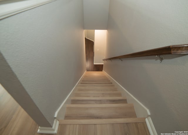 stairs featuring baseboards and wood finished floors