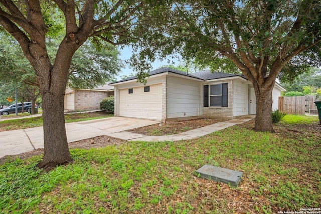 ranch-style home featuring brick siding, fence, driveway, and a garage