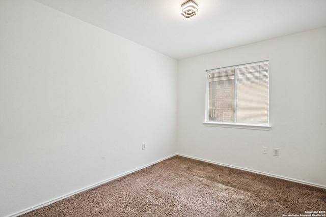 unfurnished room featuring carpet floors and baseboards