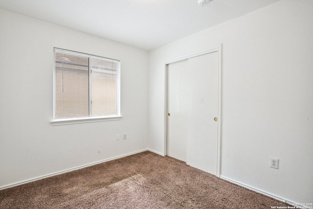unfurnished bedroom with a closet and carpet flooring