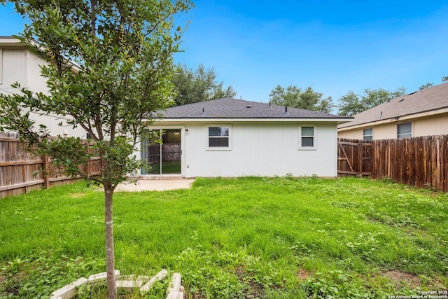 back of house featuring a lawn and a fenced backyard