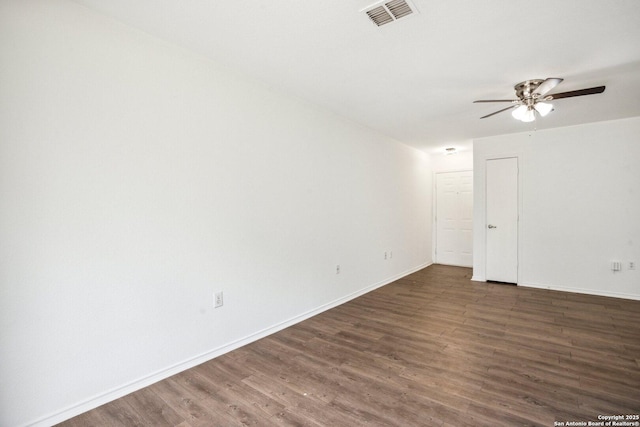 spare room featuring baseboards, ceiling fan, visible vents, and wood finished floors