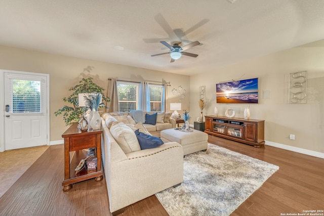 living area featuring a ceiling fan, baseboards, and wood finished floors