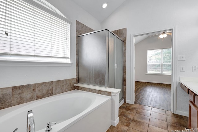 bathroom with vanity, a shower stall, vaulted ceiling, and a garden tub