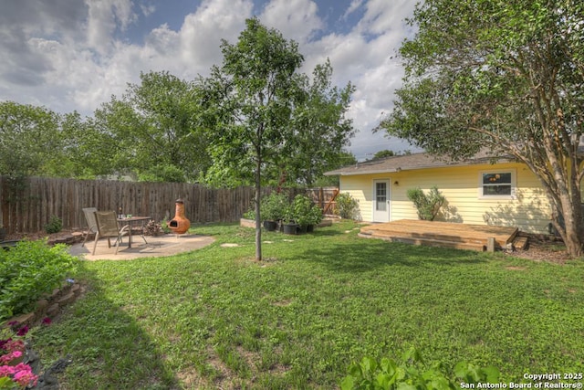 view of yard with a patio, a fenced backyard, and a wooden deck