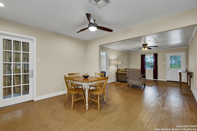 dining room featuring visible vents, a ceiling fan, baseboards, and wood finished floors