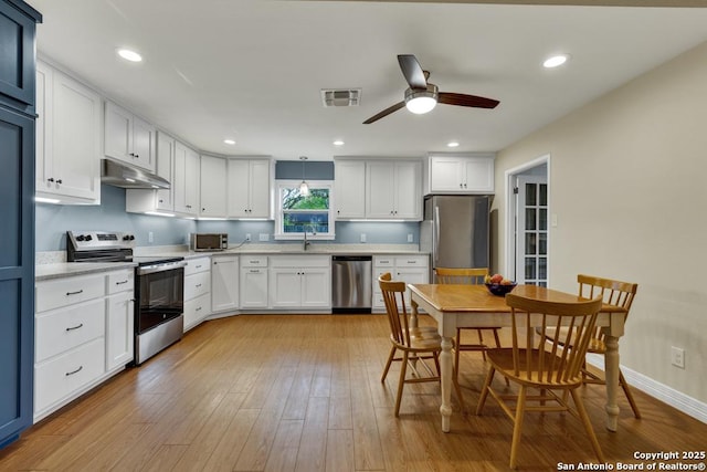 kitchen with ceiling fan, a sink, stainless steel appliances, under cabinet range hood, and visible vents