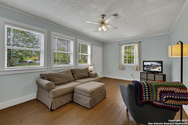 living room with ornamental molding, a textured ceiling, ceiling fan, and wood finished floors
