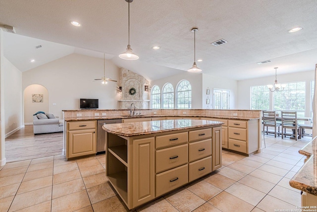 kitchen featuring ceiling fan with notable chandelier, a large island, open floor plan, stainless steel dishwasher, and visible vents