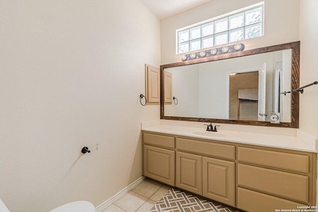 half bathroom with vanity, baseboards, and tile patterned floors