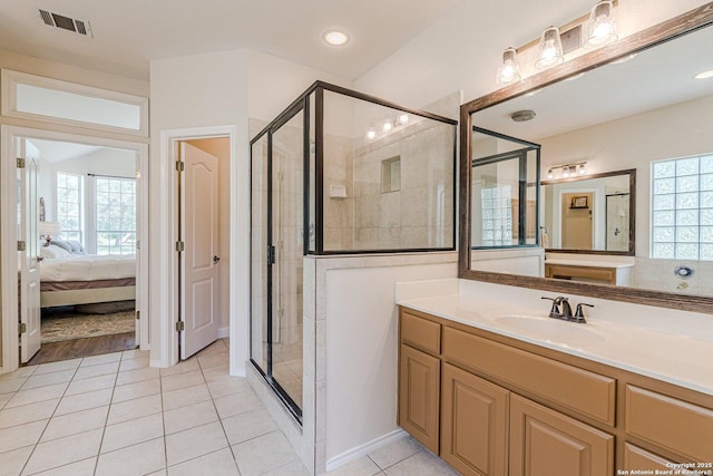 ensuite bathroom with a healthy amount of sunlight, a stall shower, and visible vents