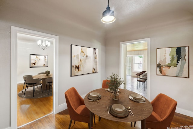 dining room featuring baseboards, an inviting chandelier, and wood finished floors