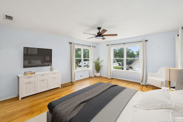 bedroom with visible vents, a ceiling fan, baseboards, and light wood-type flooring