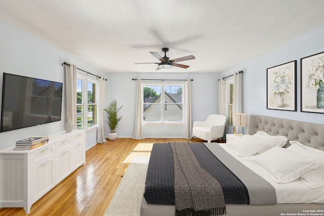 bedroom featuring baseboards, a ceiling fan, and light wood-type flooring