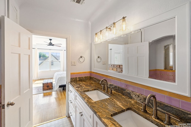 bathroom featuring double vanity, a sink, a ceiling fan, and visible vents