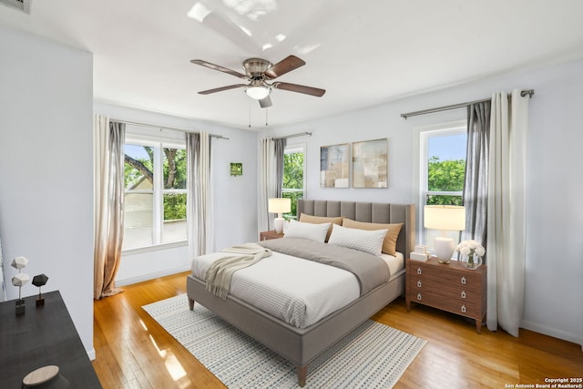 bedroom featuring baseboards, visible vents, ceiling fan, and light wood-style floors