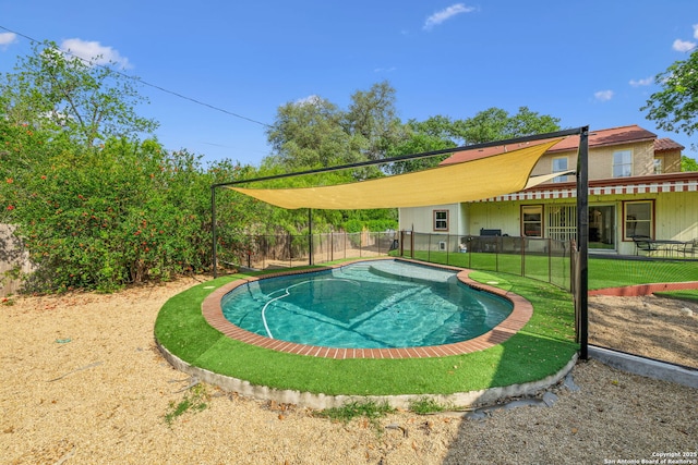 view of swimming pool featuring fence and a yard
