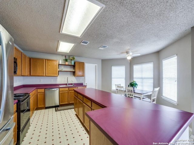 kitchen with a textured ceiling, visible vents, open shelves, a sink, and black appliances