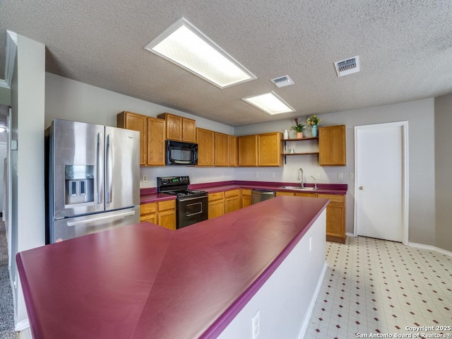 kitchen with visible vents, open shelves, a sink, and black appliances