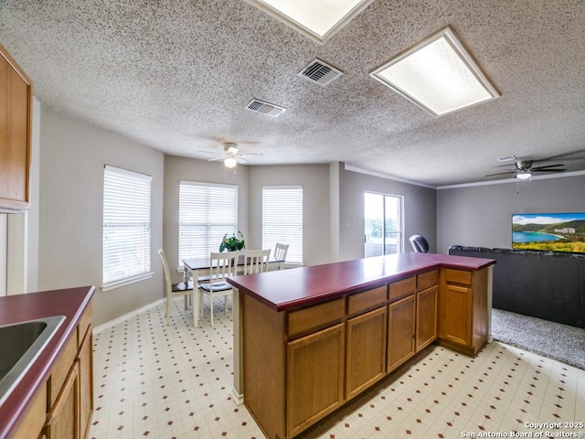kitchen featuring a ceiling fan, visible vents, and light floors
