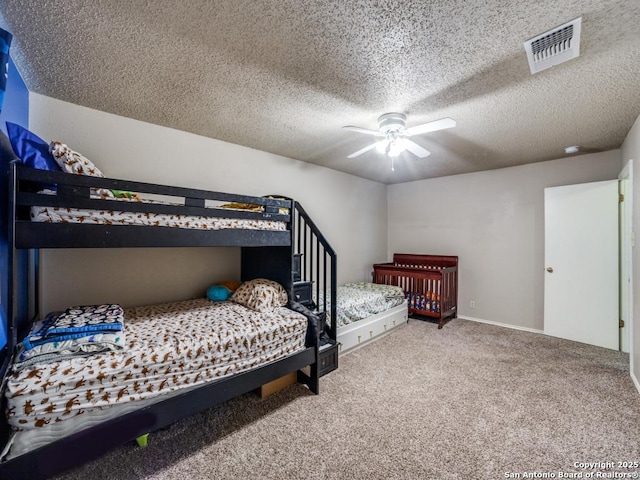 carpeted bedroom with a ceiling fan, a textured ceiling, and visible vents