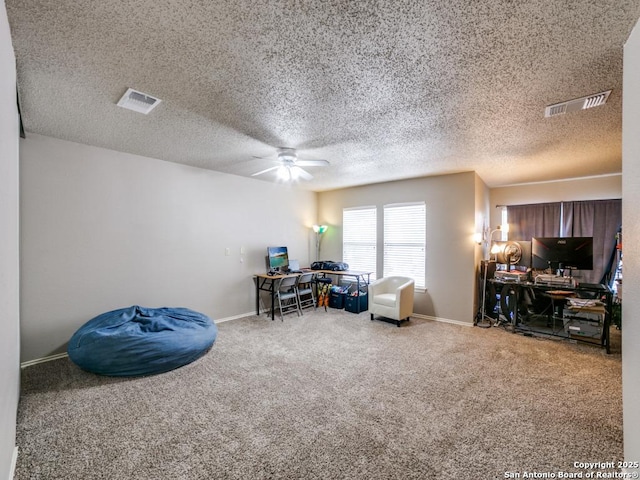 interior space with carpet flooring, a ceiling fan, a textured ceiling, and visible vents