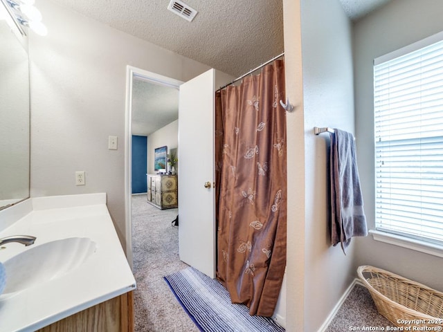 full bathroom with visible vents, a textured ceiling, and vanity