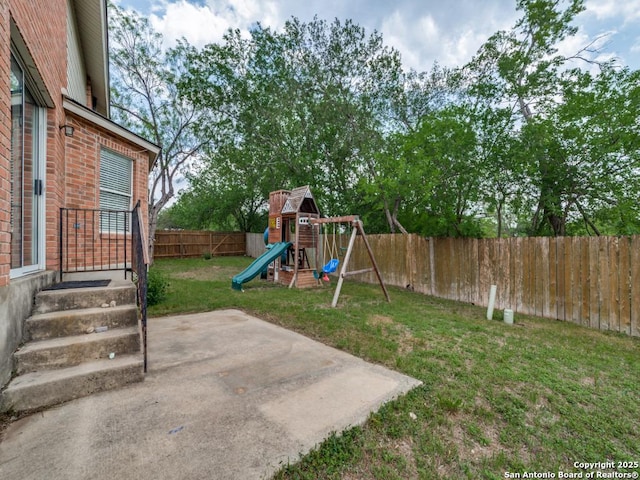view of yard featuring a patio, a fenced backyard, and a playground