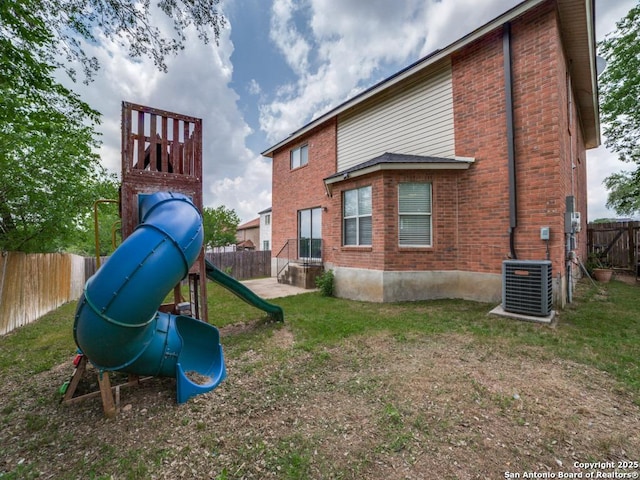 view of jungle gym with a fenced backyard, a yard, and cooling unit