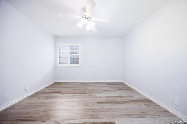 spare room featuring baseboards, a ceiling fan, and wood finished floors