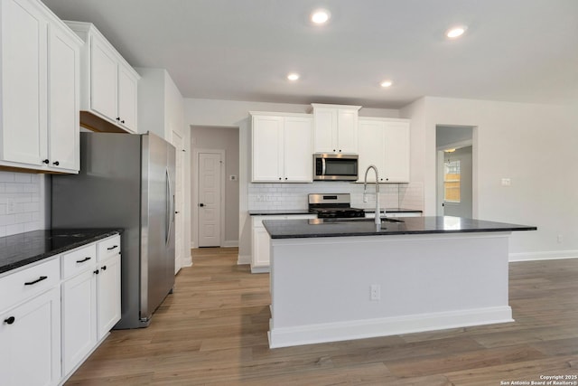 kitchen with decorative backsplash, white cabinetry, and appliances with stainless steel finishes