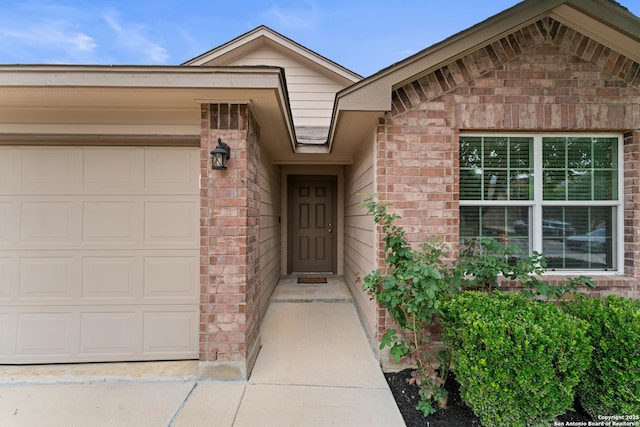 property entrance featuring brick siding and an attached garage