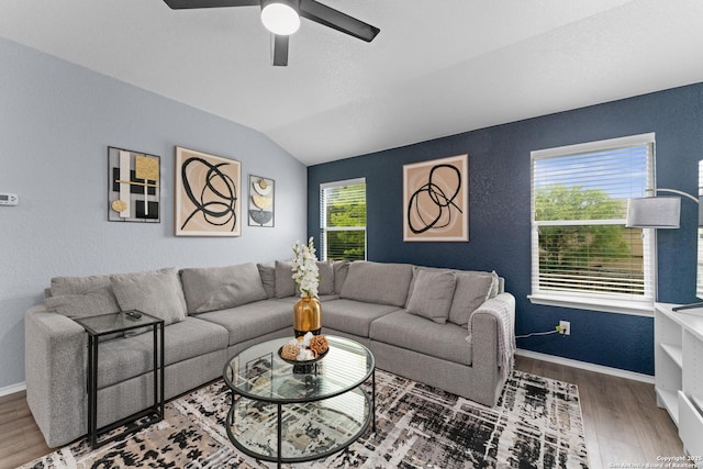 living area featuring baseboards, a ceiling fan, lofted ceiling, and wood finished floors