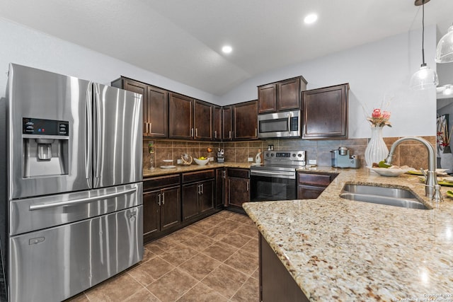 kitchen featuring dark brown cabinetry, appliances with stainless steel finishes, a sink, and light stone counters