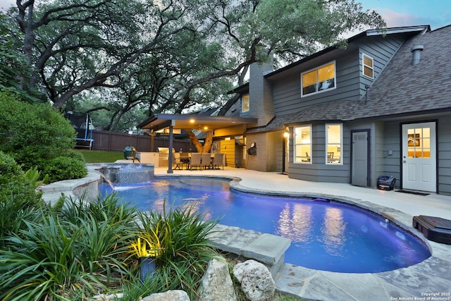 view of pool featuring fence, a patio, outdoor dry bar, a fenced in pool, and a trampoline