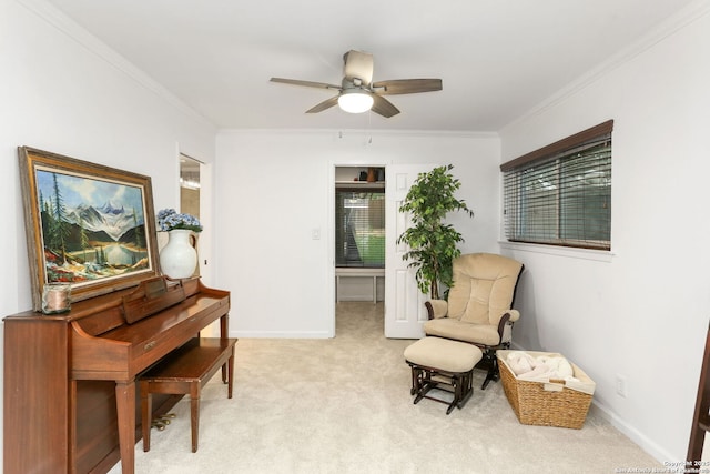 sitting room with crown molding, baseboards, ceiling fan, and light carpet