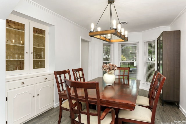 dining area with crown molding, dark wood finished floors, baseboards, and a notable chandelier