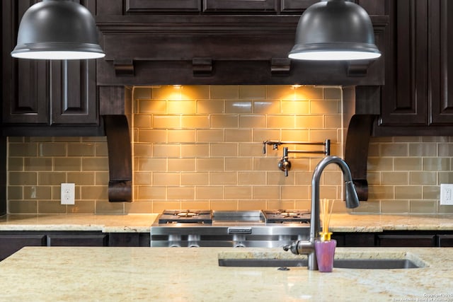 kitchen with dark brown cabinets, range, light stone counters, and decorative backsplash