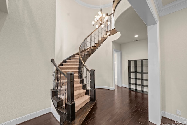 staircase with crown molding, baseboards, a notable chandelier, and wood finished floors