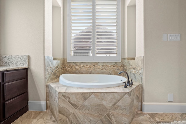 full bath featuring baseboards and a bath