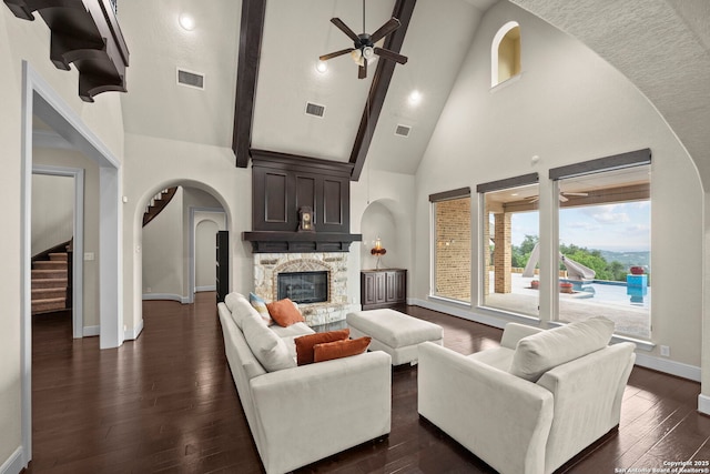 living room with ceiling fan, a fireplace, high vaulted ceiling, baseboards, and visible vents