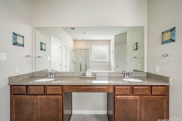 bathroom with double vanity, a sink, and a stall shower