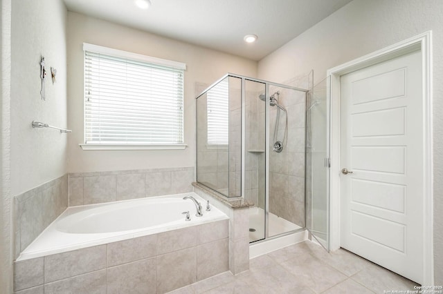 bathroom with tile patterned flooring, a bath, and a shower stall