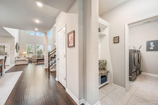 hall featuring visible vents, stairway, recessed lighting, electric panel, and washing machine and clothes dryer