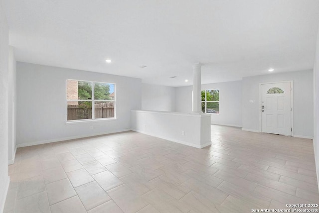 11202 Forest Pass, Live Oak, TX 78233 - unfurnished living room with recessed lighting, baseboards, ornate columns, and a wealth of natural light